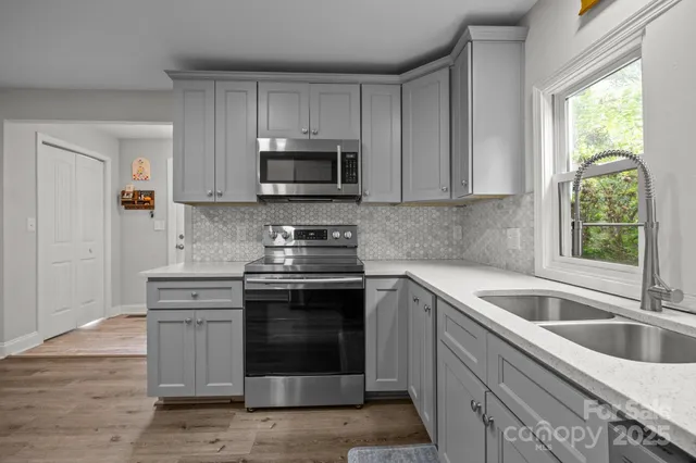 a kitchen with stainless steel appliances granite countertop a sink and a stove