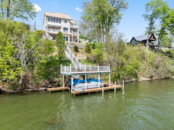 a front view of a house with yard and parking