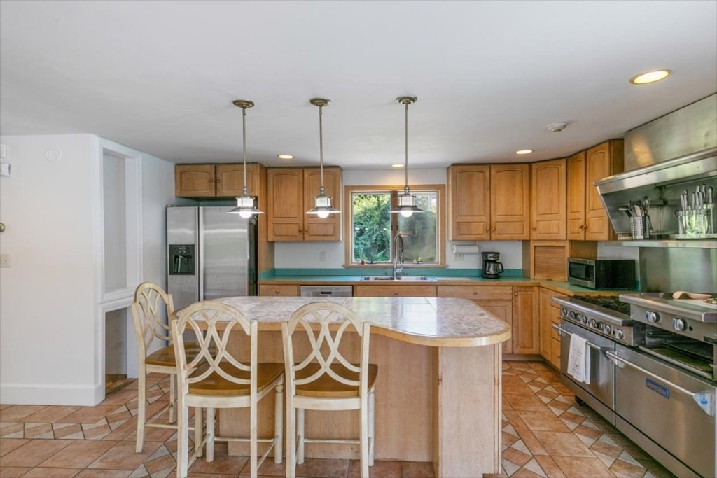 16 Crescent Avenue Beverly, MA 01915 - Photo 14 of 37 a kitchen with stainless steel appliances granite countertop a kitchen island a stove a refrigerator and a view of living room