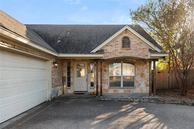 a view of a house with large windows and a small yard