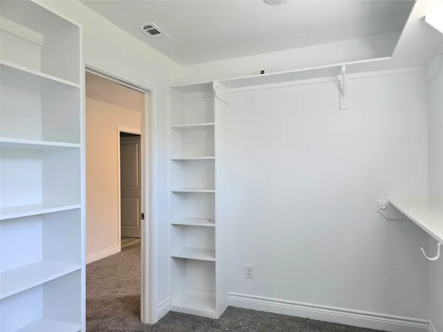 a view of walk in closet with empty racks