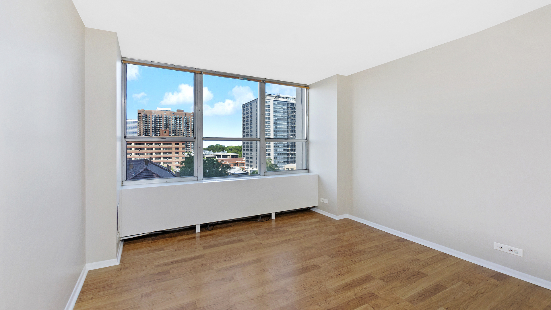 655 West Irving Park Road, Unit 710 Chicago, IL 60613 - Photo 13 of 24 an empty room with wooden floor and windows