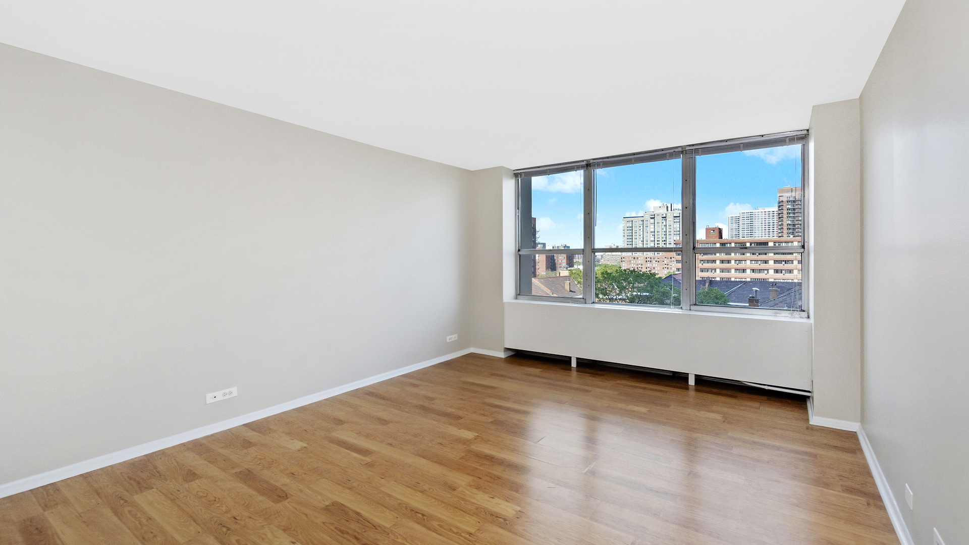 655 West Irving Park Road, Unit 710 Chicago, IL 60613 - Photo 9 of 24 an empty room with wooden floor and windows