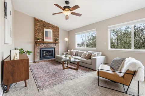 a living room with furniture a fireplace and a large window