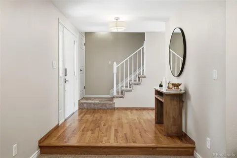 a room with wooden floor and potted plant