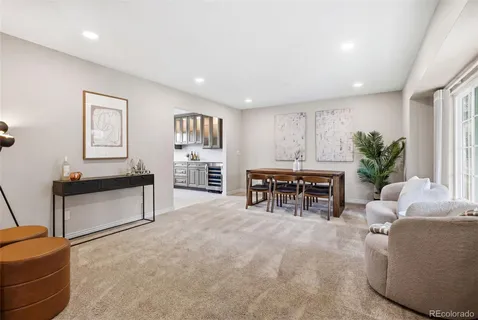 a living room with furniture and a dining table with kitchen view