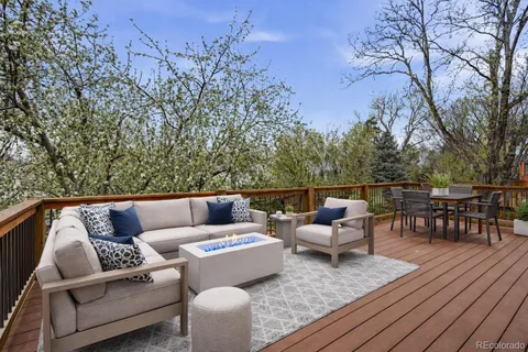 a roof deck with couches and wooden floor