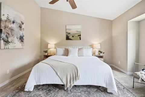 a bedroom with a bed and painting on the wall
