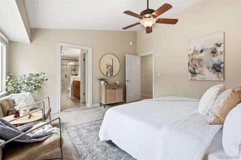 a bedroom with a bed a couch and a chandelier