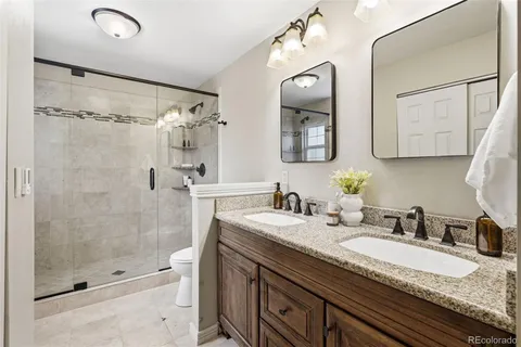 a bathroom with a granite countertop sink mirror and shower