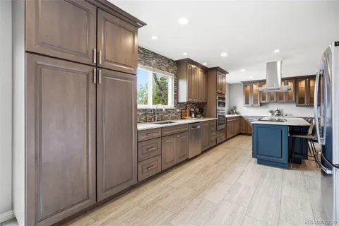 a large kitchen with a large window and stainless steel appliances