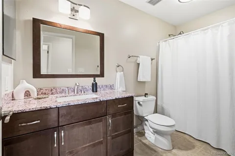 a bathroom with a toilet sink vanity and mirror