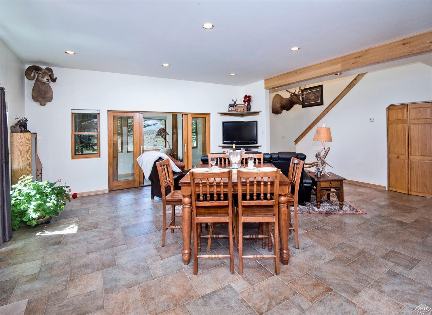 1720 Castle Peak Ranch Road Eagle, CO 81631 - Photo 3 of 25 a dining room filled chandelier and kitchen view