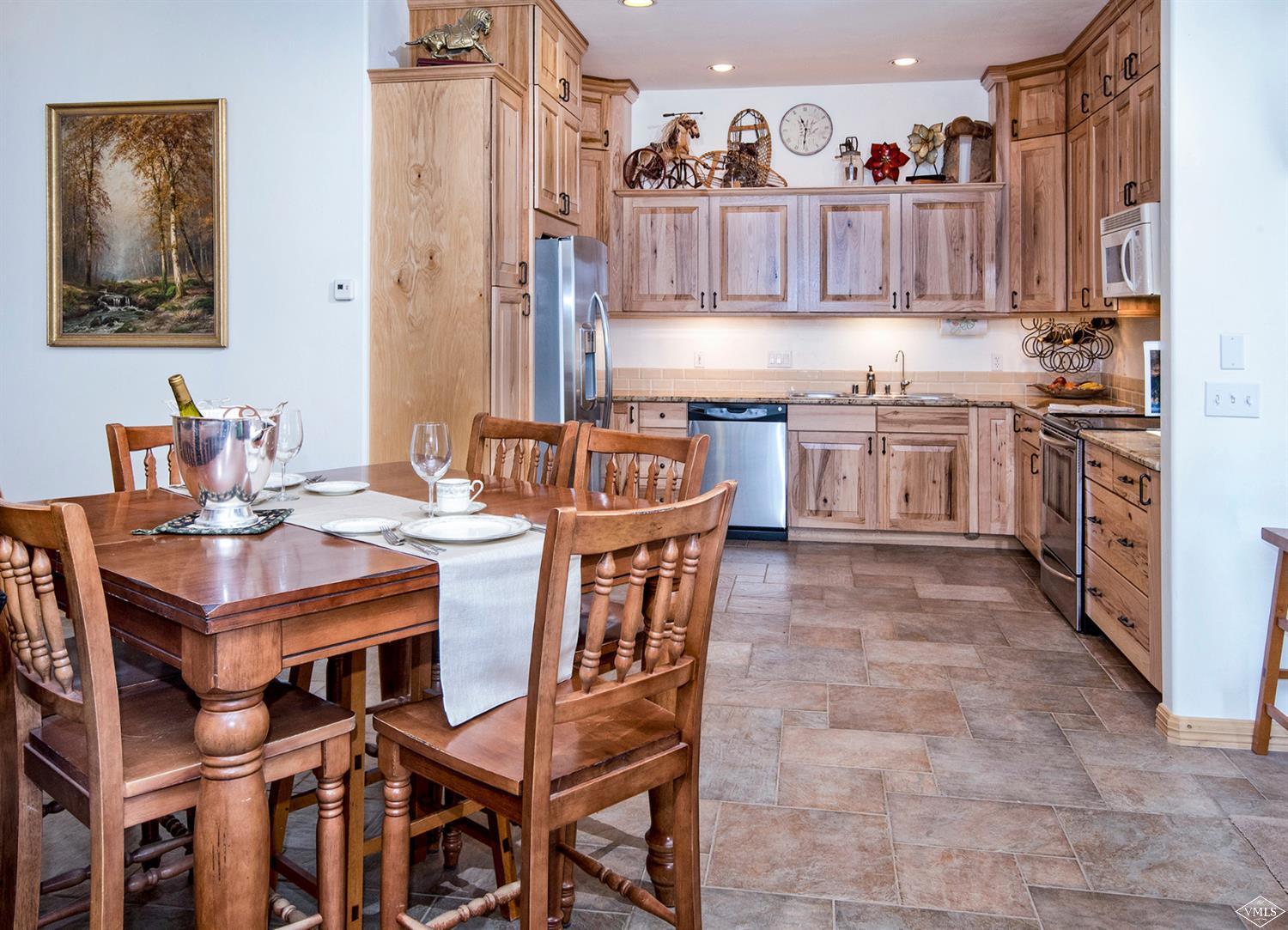 1720 Castle Peak Ranch Road Eagle, CO 81631 - Photo 6 of 25 a kitchen with a table chairs a sink dishwasher and cabinets