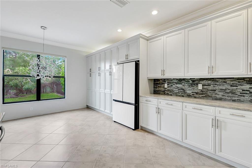 3430 Tigris Lane Naples, FL 34119 - Photo 2 of 48 a kitchen with stainless steel appliances granite countertop a refrigerator a stove and white cabinets with granite countertops