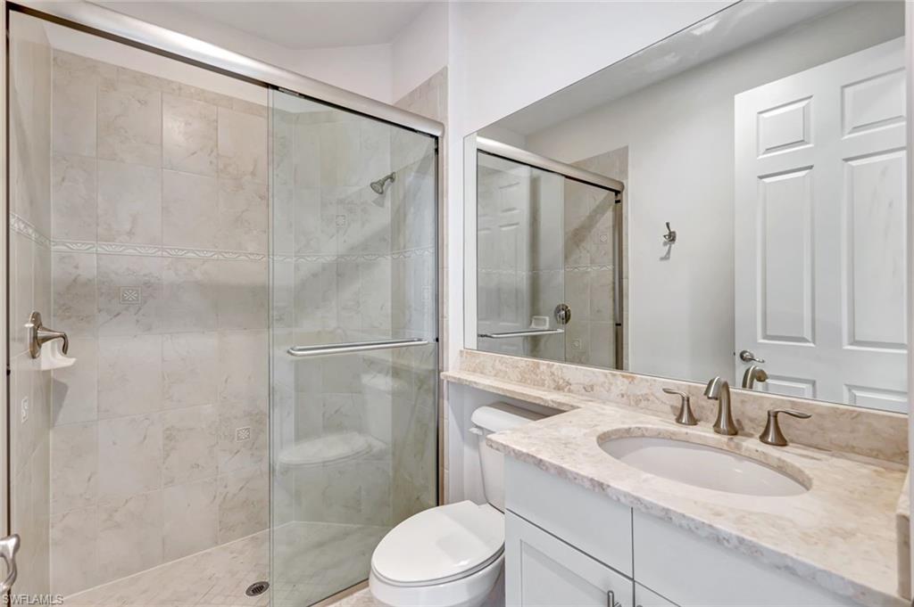 3430 Tigris Lane Naples, FL 34119 - Photo 24 of 48 a bathroom with a granite countertop sink toilet and shower
