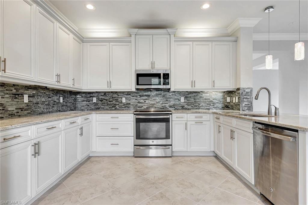3430 Tigris Lane Naples, FL 34119 - Photo 3 of 48 a kitchen with granite countertop white cabinets and white stainless steel appliances