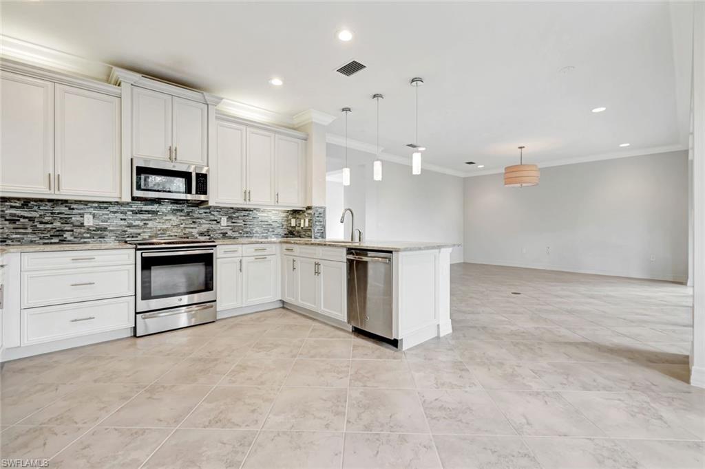 3430 Tigris Lane Naples, FL 34119 - Photo 4 of 48 a kitchen with stainless steel appliances granite countertop a stove top oven a sink and a refrigerator