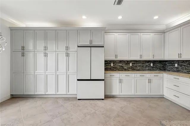 a kitchen with white cabinets and white appliances