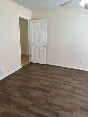 a view of an empty room with wooden floor