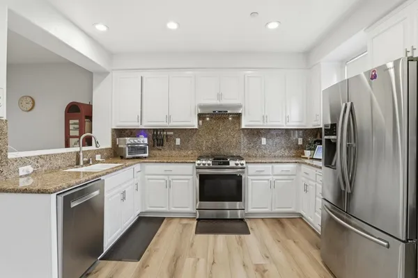 a kitchen with a refrigerator sink and cabinets