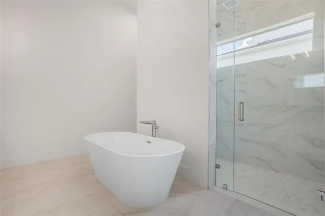 a white bath tub sitting next to a shower