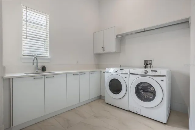 a utility room with sink dryer and washer