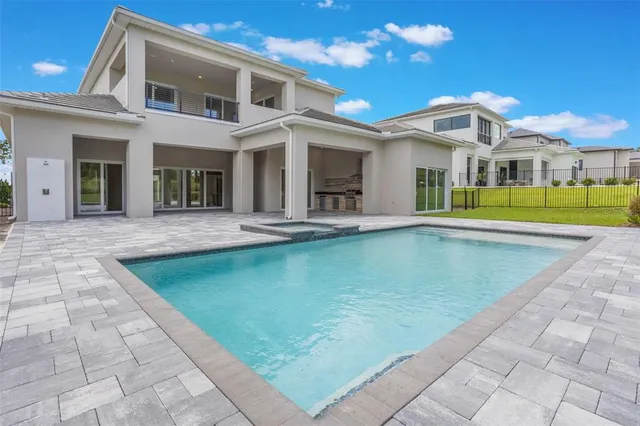 a view of a white building with a swimming pool and furniture