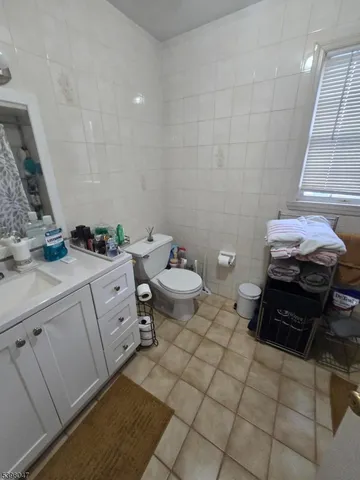 a bathroom with a granite countertop sink a toilet and a mirror