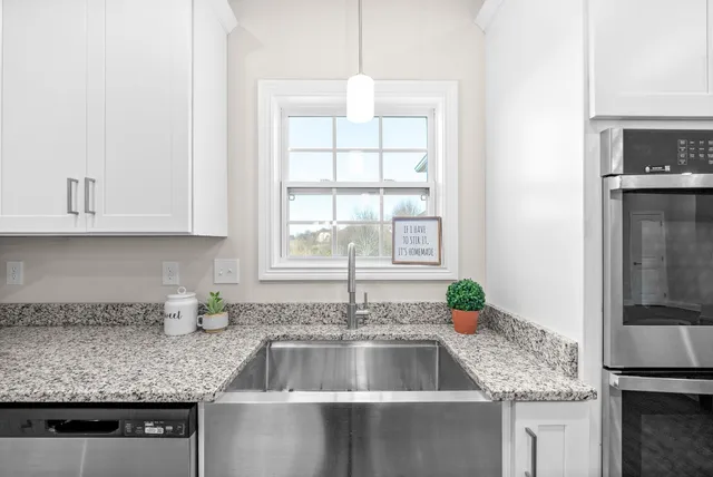a kitchen with granite countertop a sink and a stove