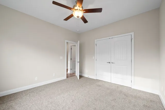 a view of a room with a ceiling fan and a window
