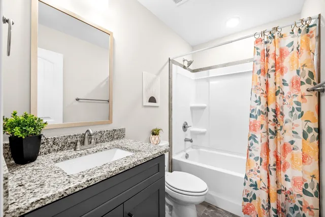a bathroom with a granite countertop sink toilet and shower