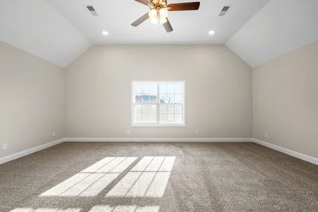 an empty room with a window and ceiling fan