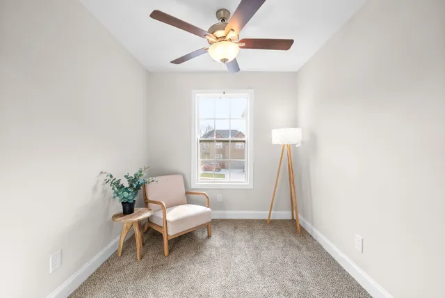 a view of a hallway with a livingroom and a bathroom