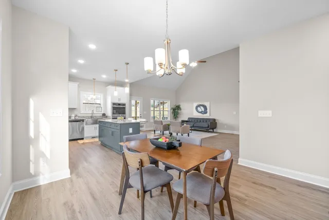 a view of a dining room with furniture a chandelier and wooden floor