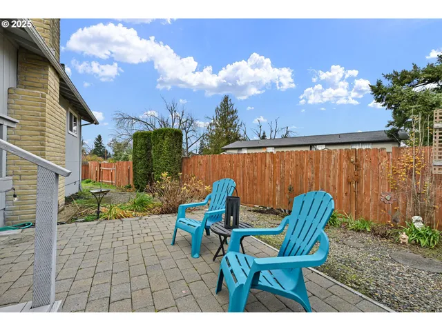 a view of a chairs and table in the backyard