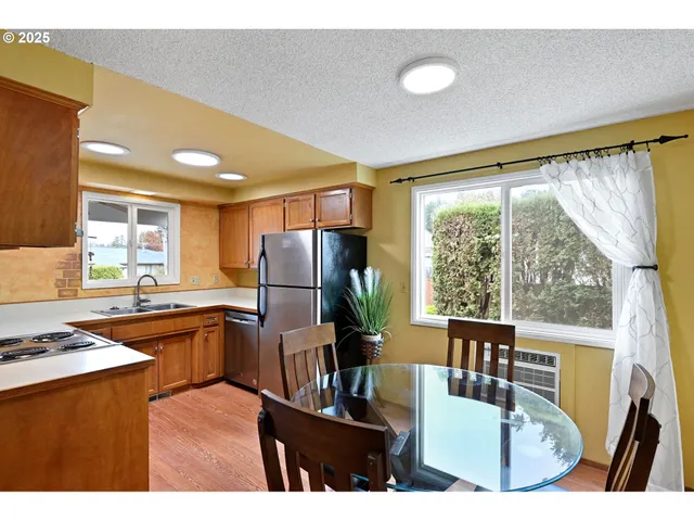 a kitchen with a table chairs refrigerator and stove