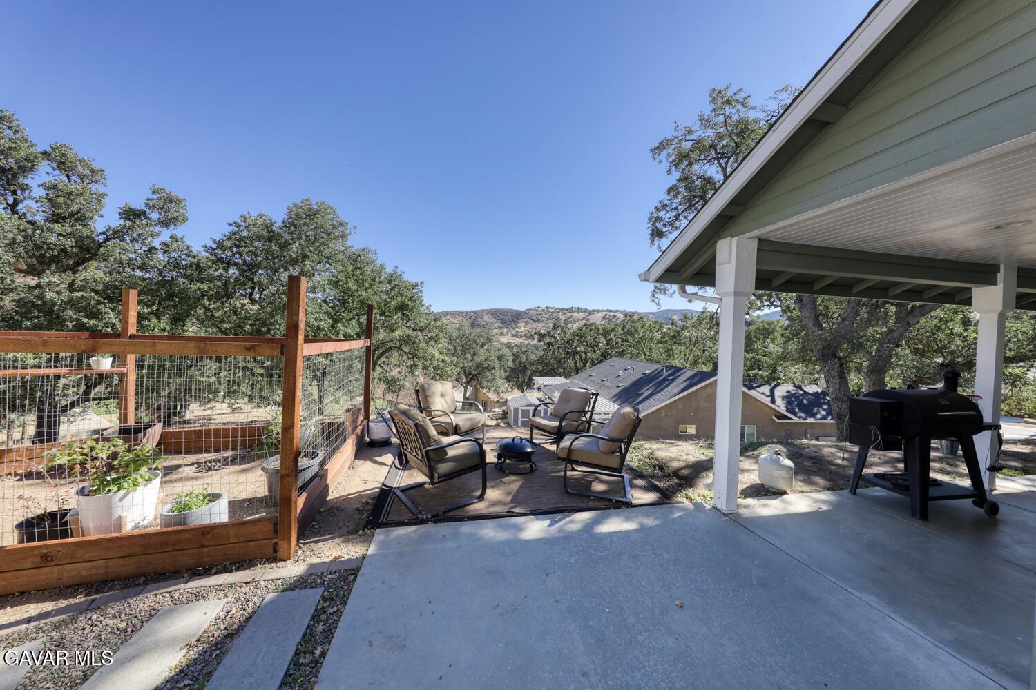 22311 Zurich Drive Tehachapi, CA 93561 - Photo 25 of 37 a view of a patio with couches table and chairs and wooden floor next to a yard