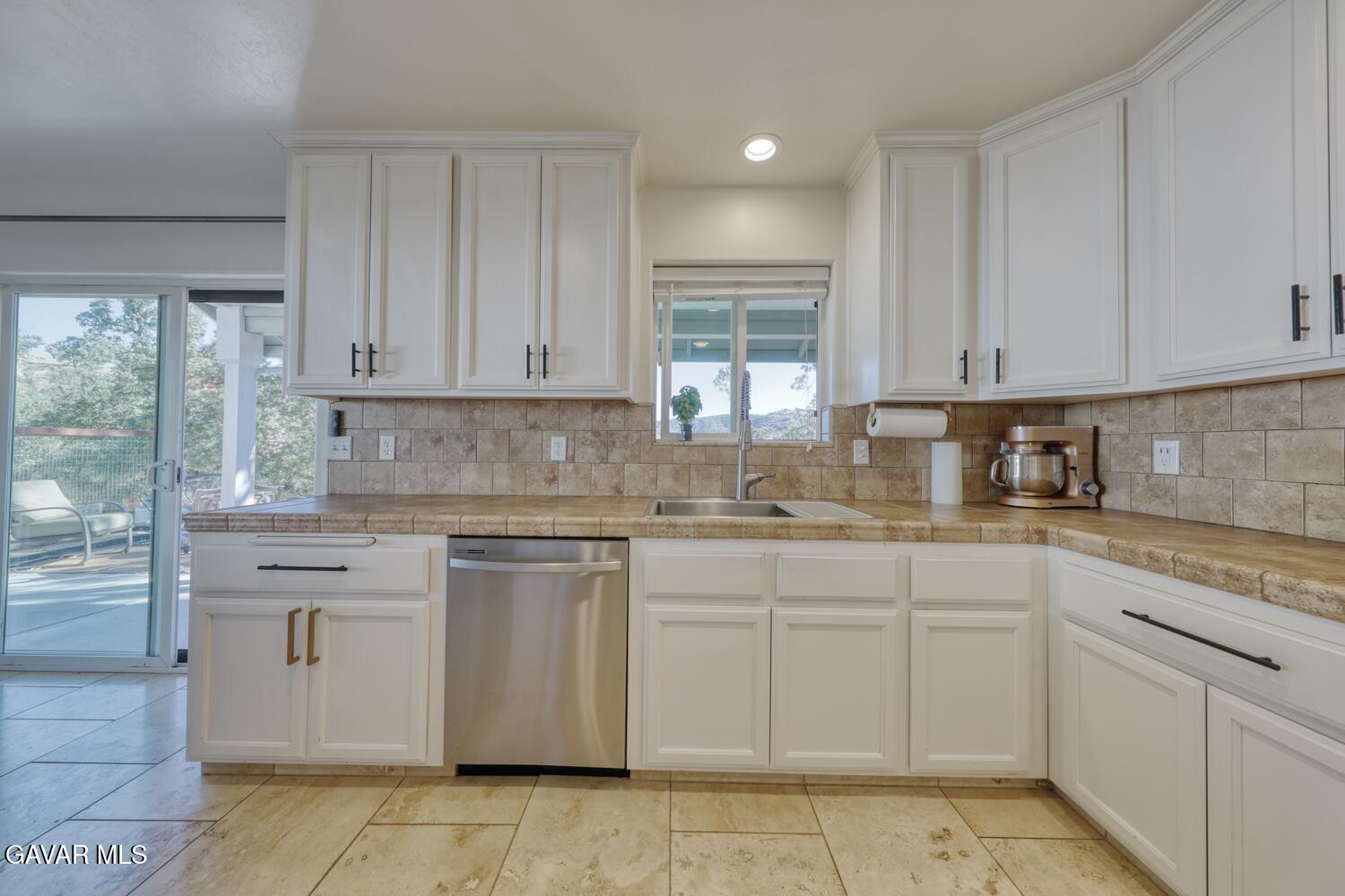 22311 Zurich Drive Tehachapi, CA 93561 - Photo 7 of 37 a kitchen with white cabinets granite counter tops and a stove