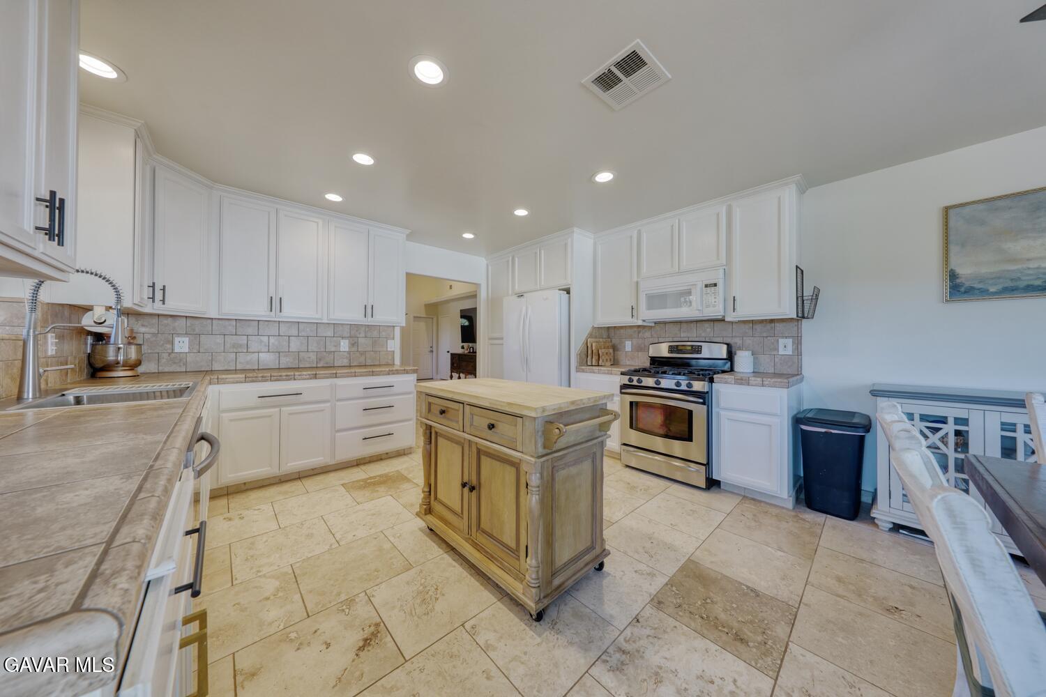 22311 Zurich Drive Tehachapi, CA 93561 - Photo 9 of 37 a kitchen with stainless steel appliances granite countertop a stove top oven a sink and a refrigerator
