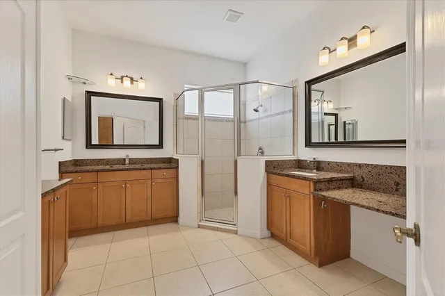 a bathroom with a granite countertop sink a mirror and a cabinets