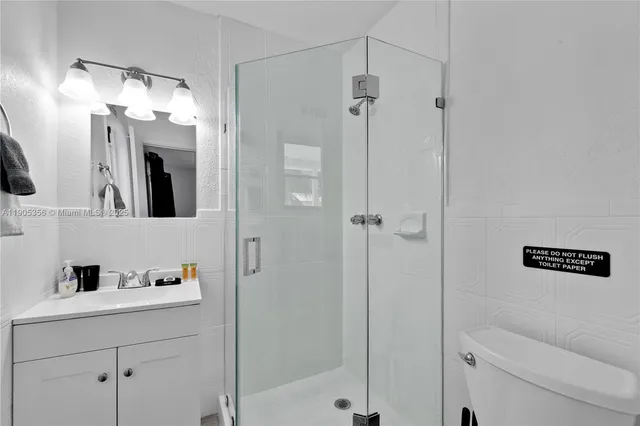 a bathroom with a shower a sink and a mirror