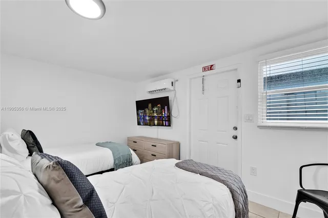 a bedroom with two beds and a window