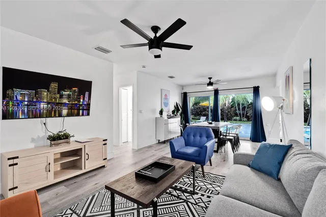 a living room with furniture a ceiling fan and a window