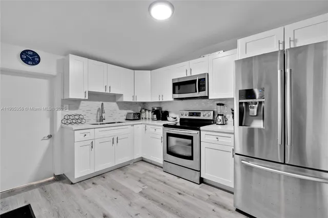 a kitchen with granite countertop a refrigerator stove and microwave