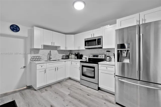 a kitchen with granite countertop a refrigerator stove and microwave