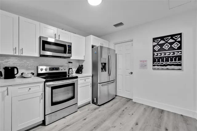 a kitchen with stainless steel appliances a stove microwave and a refrigerator
