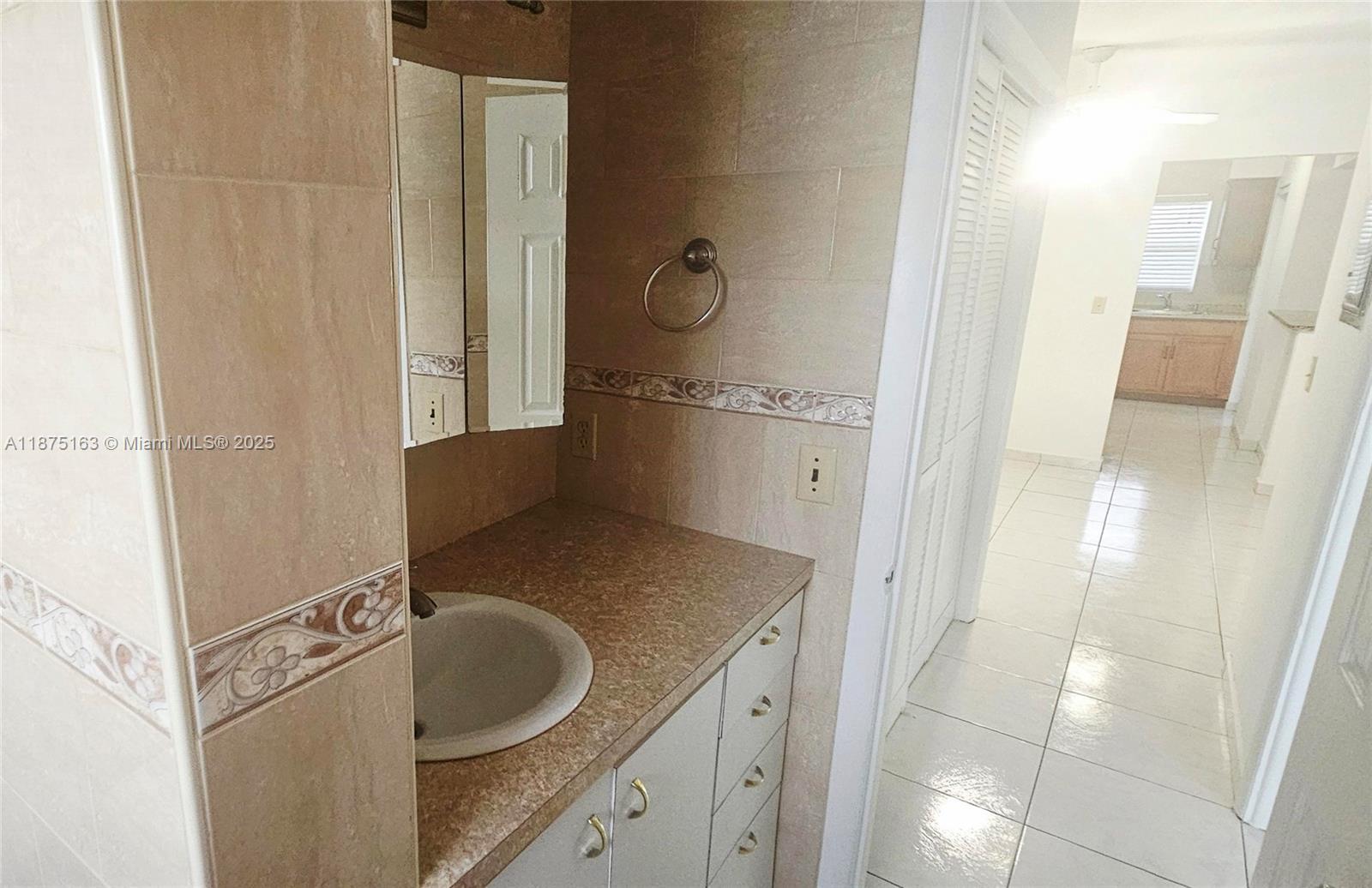 141 Northeast 10th Avenue, Unit 22C Hallandale Beach, FL 33009 - Photo 14 of 16 a bathroom with a granite countertop sink and a mirror