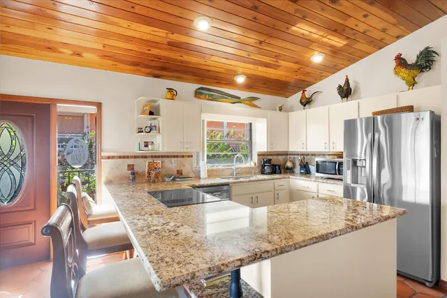 a kitchen with stainless steel appliances granite countertop a sink window and cabinets