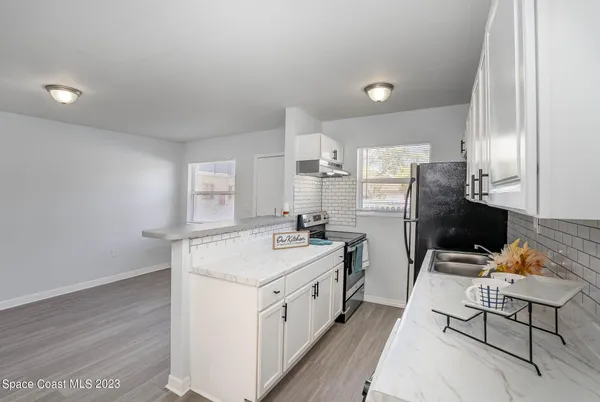 a kitchen with a sink a stove a refrigerator and cabinets